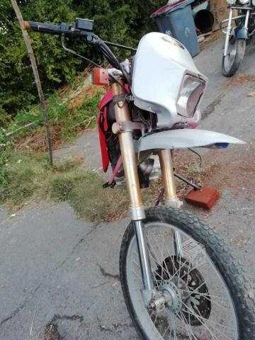 Motocicleta en duro roja con blanco kawasaki 200cc